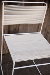White horizontal spaghetti strings and metal frame of a Vintage Flyline chair.