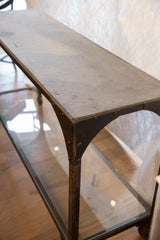Antique industrial table with rough gray soapstone top and dark riveted cast iron frame.