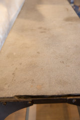 Rough light gray soapstone top surface of the antique industrial table.