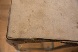 Rough side of the antique industrial soapstone table's top, showing texture and age.