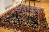 Angled view of the distressed texture and floral pattern on a vintage Persian Bibikabad rug.