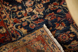 Folded corner of a distressed Bibikabad rug showing its hand-knotted back and low wool pile.