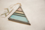 Pastel pink, cream, green, and blue stained glass triangle with lead came detail.