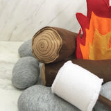 Close-up of Kids Campfire Toy, featuring felt log with stitched rings, grey rocks, white marshmallow.