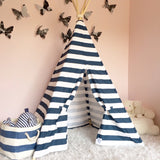 Rope-bound natural wood poles atop the navy and white striped teepee.