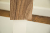 Walnut wood veneer with prominent grain atop the white plaster modern table lamp.