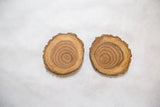 Natural wooden coaster's live edge and concentric wood grain.
