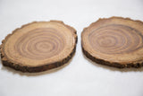 Live edge detail of a natural wooden coaster, showing bark and wood grain.
