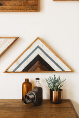 Reclaimed wood art with geometric stripes in whitewashed, charred, and blue tones.