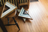 Reclaimed wood triangle art: charred, whitewashed, cornflower blue stripes, subtle rose quartz.