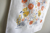 Leah Duncan Meadow tea towel detail, natural linen texture with orange, yellow, blue floral print.