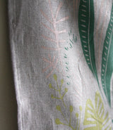 Textured linen Planty tea towel's hemmed edge with screen-printed green and pale pink botanicals.