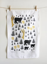 Leah Duncan Territory linen tea towel with black bears, gold rabbits, and trees.