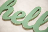 Vintage style seafoam green Hello sign detail, showing distressed wood texture.