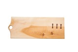 Maple wood cutting board with natural grain and dark bow-tie inlays, 22 inches long.