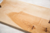 Maple wood cutting board with natural grain and dark Arikata butterfly inlays.