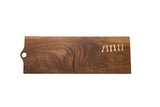 Rich walnut serving board with natural grain and light wood bow tie repairs, 30 inches long.