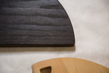 Ebonized oak charcoal cutting board close-up, revealing wood grain and minor edge wear.