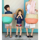 Olli Ella handwoven seagrass basket, featuring a sherbert coral-dipped base.