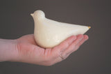 Sculptural creamy white glazed porcelain turtle dove held, gold tip.