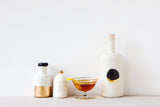 Handmade Moon Bottle with glossy white glaze, cork stopper, gold waxing moon motif.