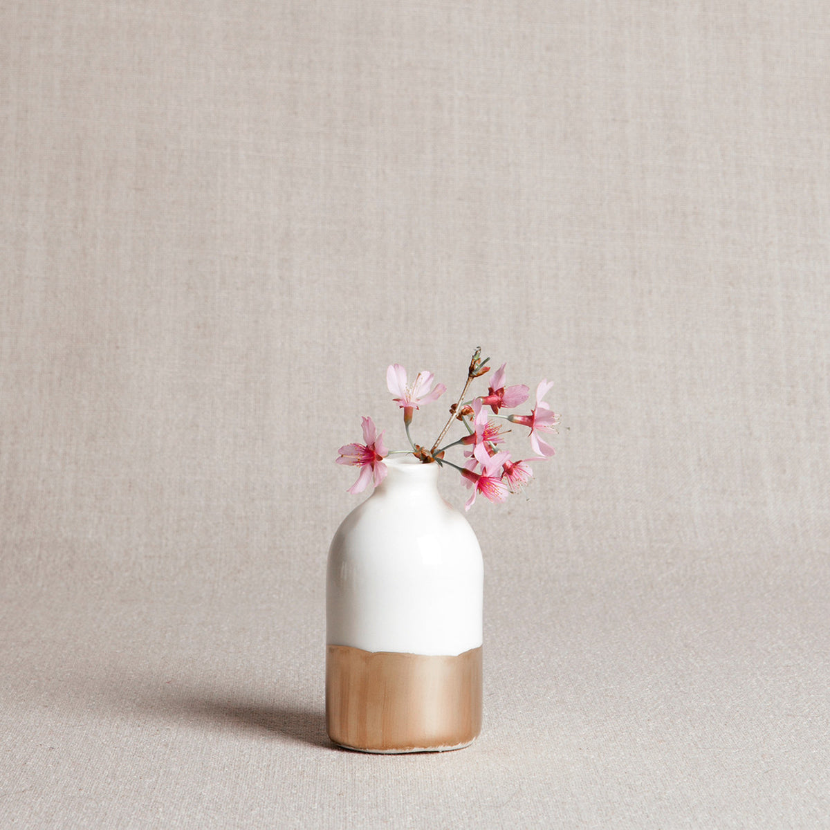 Handmade white porcelain bud vase with glossy glaze and hand-painted gold leaf base.