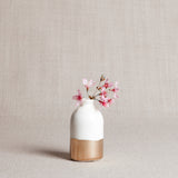 Handmade white porcelain bud vase with glossy glaze and hand-painted gold leaf base.
