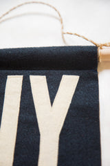 Hand-sewn cream 'IY' letters on the textured navy felt NY flag.