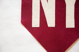 Crimson red felt flag detail with hand-sewn cream NY letters and fine stitching.