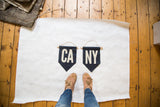Handmade navy felt flag with cream 'CA' letters on an oak dowel.