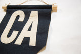 Detail of the hand-sewn cream letters and oak dowel on the navy felt CA flag.