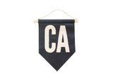 Handmade navy and cream CA felt flag with oak dowel and twine hanger, 7x10 inches.
