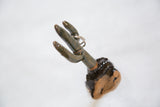 Angled dark glazed ceramic cactus totem, holding a silver ring, with speckled clay base.