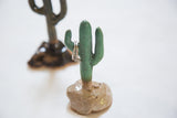 Speckled light green ceramic cactus with textured surface, holding silver rings.