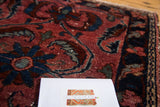 Textured pile of antique Lilihan rug, showcasing raspberry red and navy sickle leaf patterns.