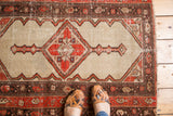 Decorative worn texture featuring bright red quatrefoil floral diamond motif on camel field Malayer rug.
