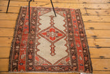 Aged edge of antique Malayer rug, with worn tomato red and brown geometric borders.
