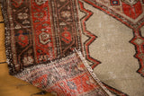Secured end, fringed edge, and hand-knotted reverse of the distressed Malayer rug.