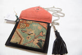 Open view of rug fragment bag highlights the coral suede interior and silver-tone hardware.