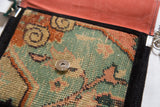Magnetic snap closure and peach vegetable suede lining inside a handmade rug fragment bag.