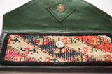 Interior view of the rug clutch showing the green suede lining and magnetic snap closure.
