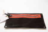 Handmade Rug Fragment Clutch close-up, black suede, coral zipper, and attached tag.