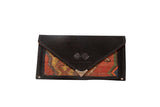 Handmade Rug Fragment Clutch by Swag and Tassel, black suede, and vibrant hand-knotted textile.