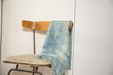 Variegated hand-dyed indigo texture with fringed edge on a collectible cotton throw.