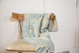 Detail of vintage indigo throw, highlighting faded blue cotton weave and distinctive stitching.