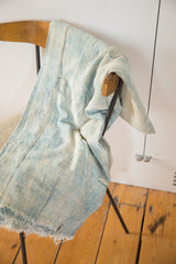 Faded light indigo hand-woven cotton textile with a prominent square patched detail.