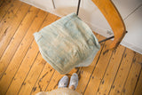 Collectible vintage light indigo throw featuring handwoven texture, stitched lines, and a round patch.