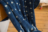 Draped vintage dark indigo cotton textile, showing unique hand-dyed patterns.