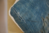 Close-up of African Indigo Throw Pillow corner showing sun-faded vintage textile with loose threads.