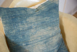 Sun-faded vintage African indigo textile showing horizontal stitching and loose threads.